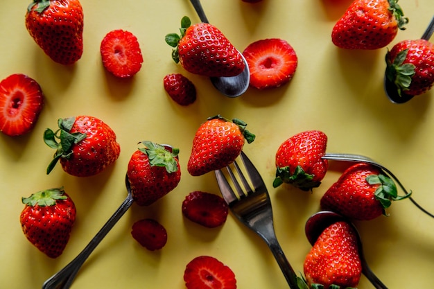 Fragola e forchette di stagione primaverile su priorità bassa gialla. Sopra la vista