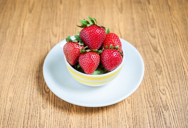 Fragola fresca e succo sul tavolo di legno. distesa piatta.