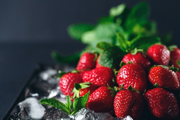 Fragola matura su ghiaccio con la foglia di menta