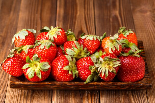 Fragola matura sul piatto di legno