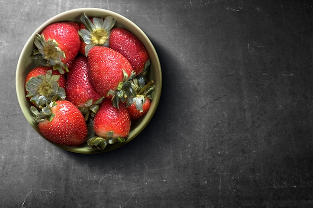 Fragola nella ciotola sul nero