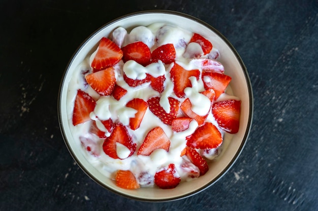 Fragola rossa e yogurt bianco brulée Dessert di frutta a colazione con spicchi di fragole perfettamente mature in primo piano di stagione