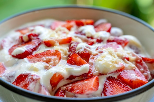 Fragola rossa e yogurt bianco brulée Dessert di frutta a colazione con spicchi di fragole perfettamente mature in primo piano di stagione