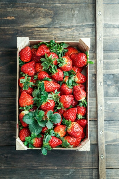 Fragola rossa matura in una scatola di legno Vista dall'alto del fondo della fragola