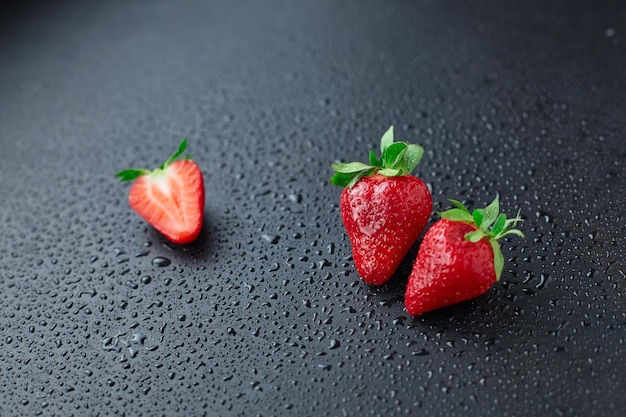 Fragola su sfondo nero con gocce di pioggia pubblicità attraente diaframma aperto molto fresco