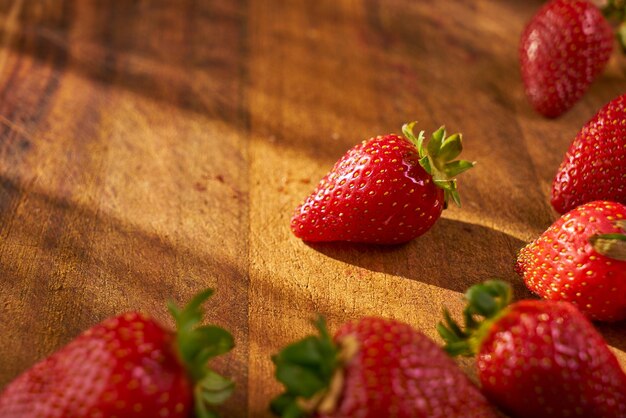 Fragole biologiche fresche su un tagliere di legno