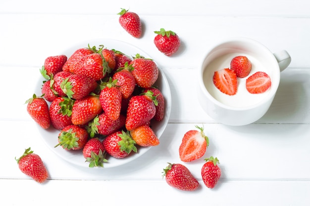 Fragole con crema su uno sfondo bianco. Mangiare sano.