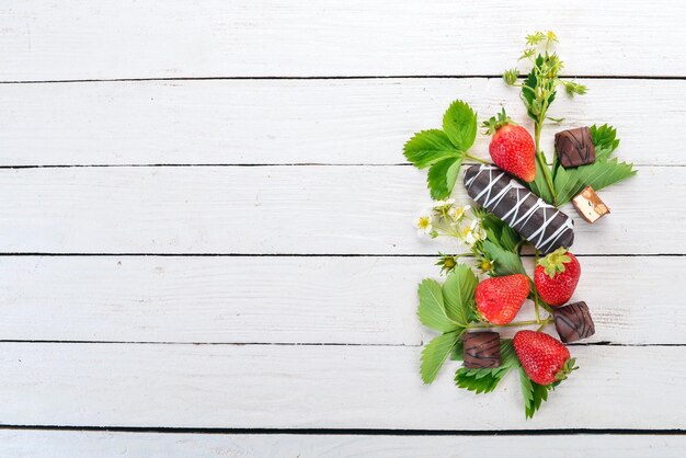 Fragole con dolci su uno sfondo di legno bianco Vista dall'alto Spazio di copia