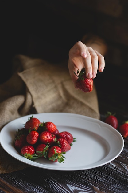 Fragole con panna Fotografia di cibo Fragole appetitose su uno sfondo di legno scuro