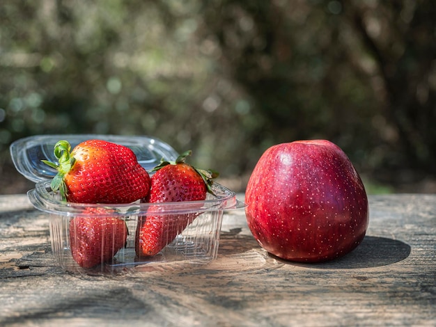 Fragole con una mela accanto