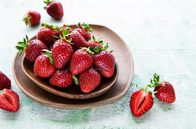 Fragole deliziose mature fresche in una ciotola di legno