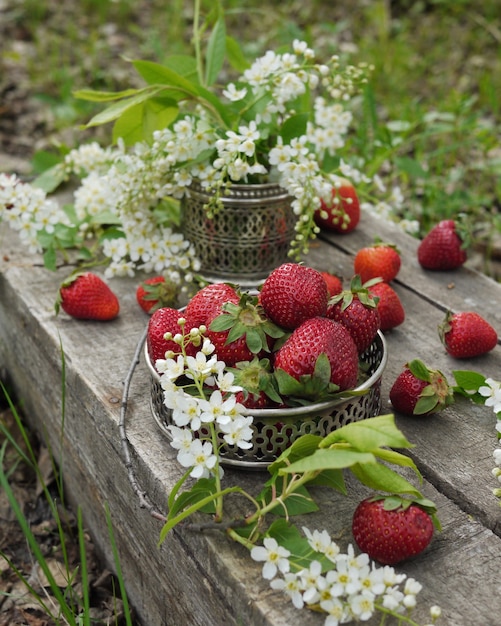 Fragole e fiori di ciliegio sul vecchio tavolo