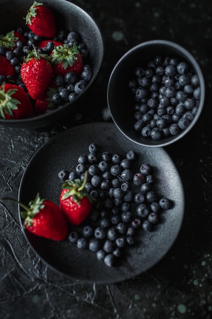 Fragole e mirtilli, cibo su sfondo nero