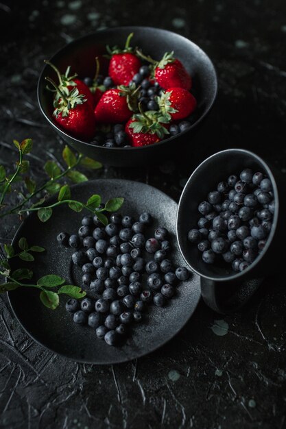 Fragole e mirtilli, cibo su sfondo nero