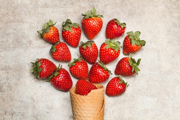 Fragole e un cono di waffer su un tavolo di marmo