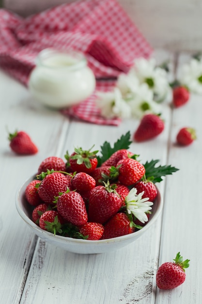 Fragole fresche in ciotola di ceramica e yogurt bio naturale