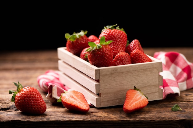 Fragole fresche in un cesto sul vecchio tavolo di legno da vicino