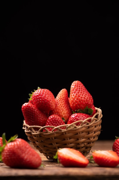 Fragole fresche in un cesto sul vecchio tavolo di legno da vicino