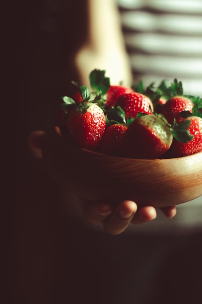 Fragole fresche in una ciotola di legno