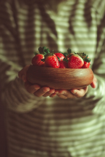 Fragole fresche in una ciotola di legno