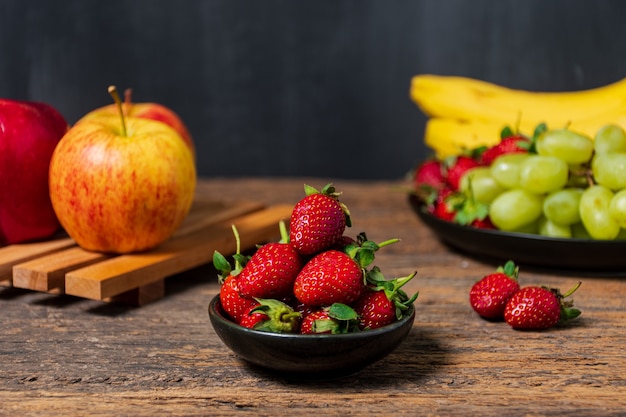 Fragole fresche mela e banana su sfondo di legno frutti sfondo