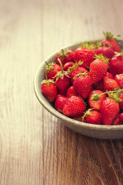 fragole fresche su fondo di legno