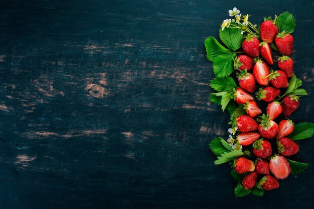 Fragole fresche su uno sfondo di legno nero Vista dall'alto Copia spazio