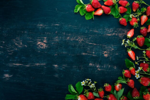 Fragole fresche su uno sfondo di legno nero Vista dall'alto Copia spazio