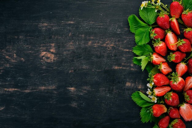 Fragole fresche su uno sfondo di legno nero Vista dall'alto Copia spazio