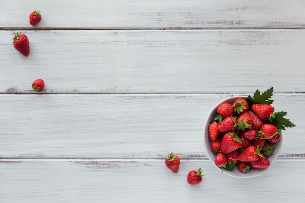 Fragole fresche sulla ciotola di ceramica ambientale