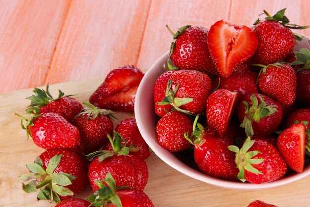 Fragole in ciotola sul tagliere sulla tavola di legno