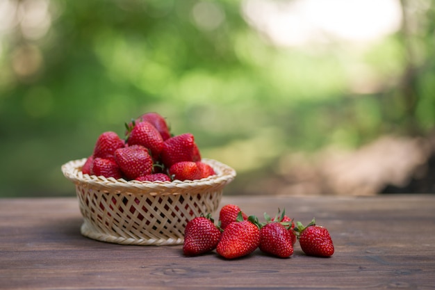 Fragole in un cestino su legno