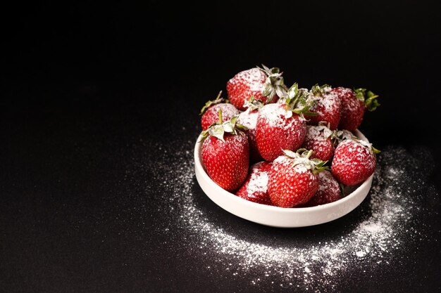 Fragole in un piatto con zucchero a velo