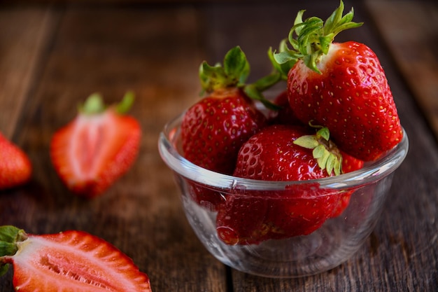 Fragole in una ciotola di legno su un vecchio tavolo di legno Cucinare in cucina