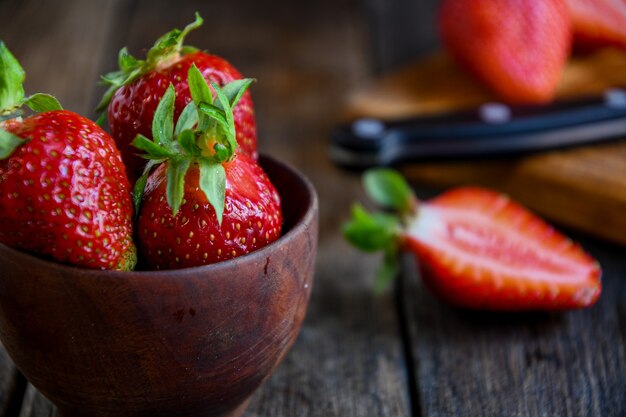 Fragole in una ciotola di legno su un vecchio tavolo di legno Cucinare in cucina