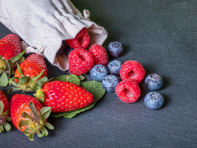 Fragole lamponi e mirtilli con sfondo grigio