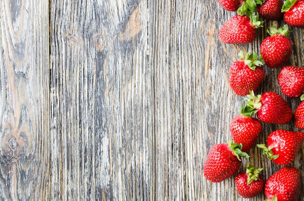 Fragole mature fresche su un fondo di legno. Bacche succose biologiche.