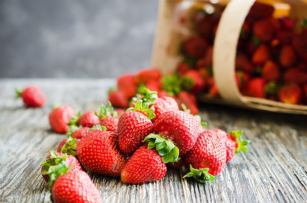 Fragole mature fresche su un fondo di legno. Bacche succose biologiche.