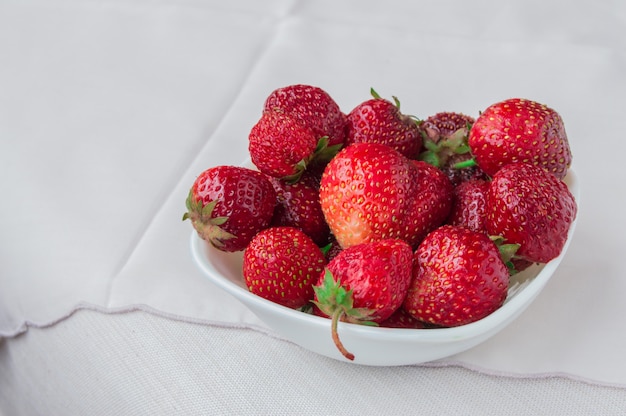 Fragole mature fresche su una tovaglia, posto per il vostro testo