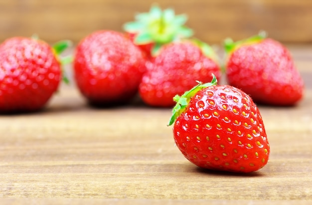 Fragole mature rosse fresche sulla tavola di legno.