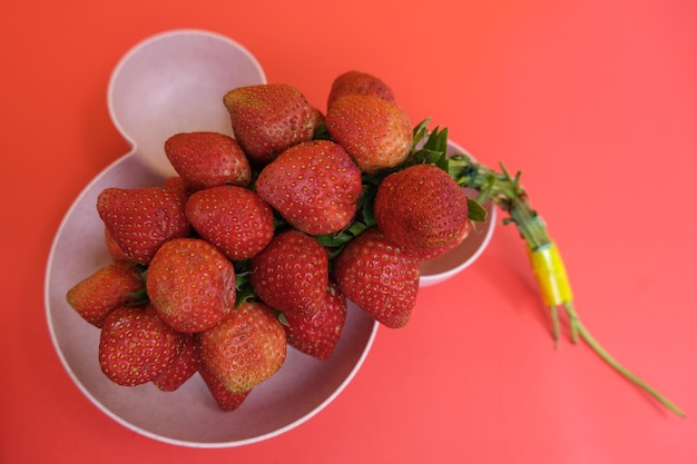 fragole nel piatto e fondo rosso