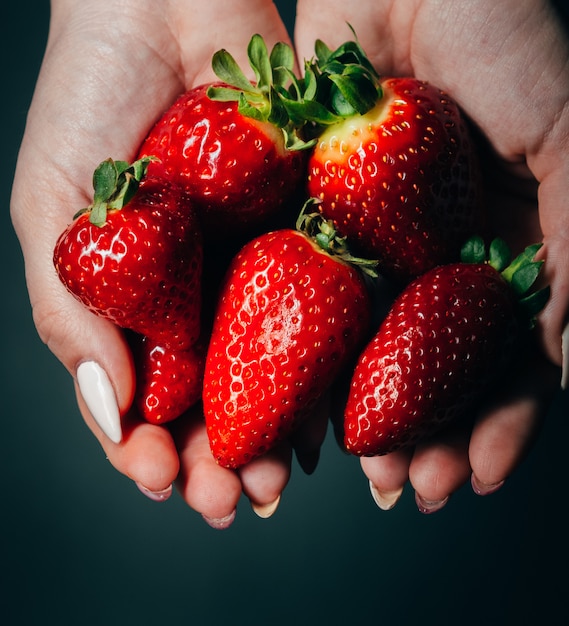 fragole nelle mani delle donne