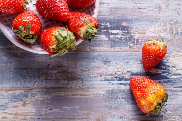 Fragole organiche mature su fondo di legno, fine su.