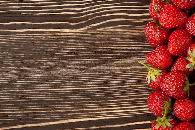 Fragole rosse fresche su una tavola di legno marrone