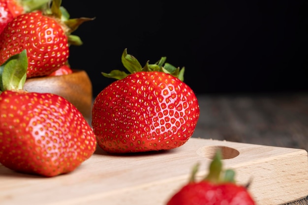 Fragole rosse mature che si trovano su un vassoio di legno