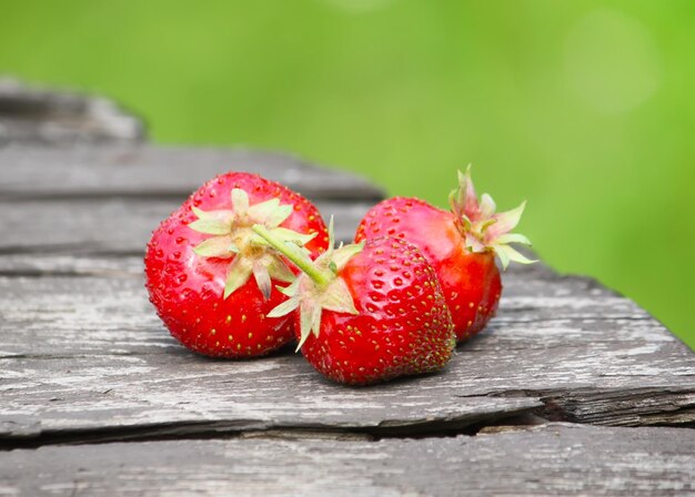 Fragole rosse mature si chiudono su un tavolo di legno all'aperto