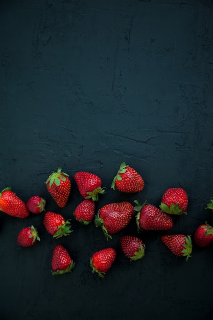 Fragole succose su sfondo nero