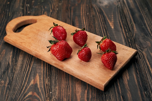 Fragole succose su un'asse da cucina in legno