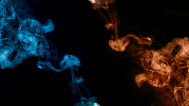 Frammenti di fumo blu e arancione su sfondo nero