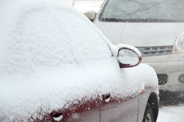 Frammenti di macchine parcheggiate coperte di neve